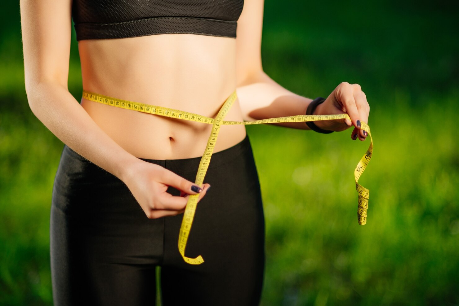 young woman measuring her thin waist with tape measure 8353 5995